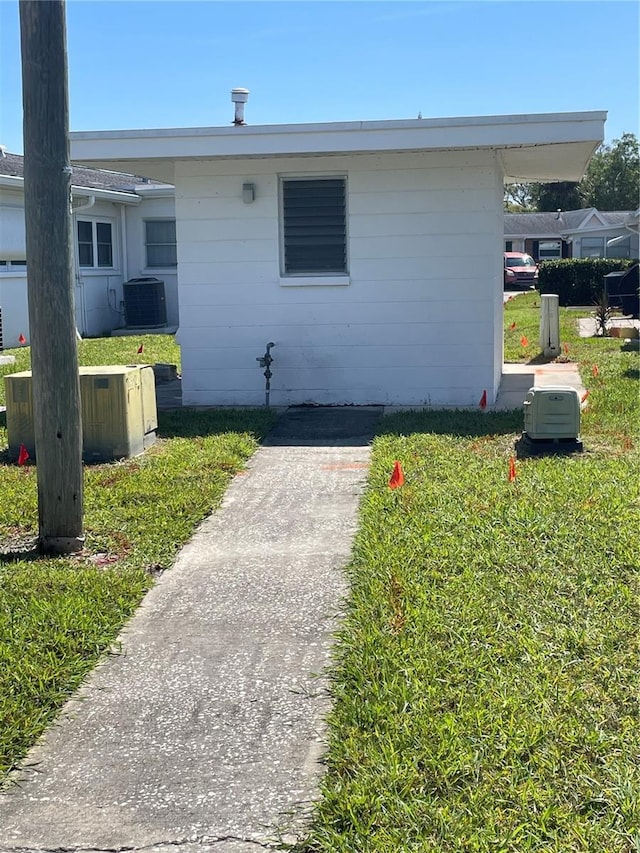 view of front of home with a front yard and central AC unit