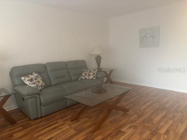 living area featuring baseboards and wood finished floors