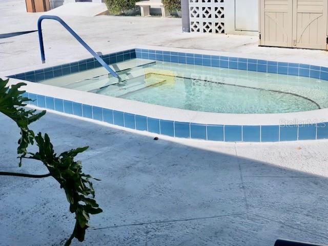 view of pool with a hot tub