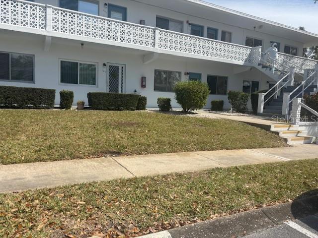 exterior space with stairs and a yard