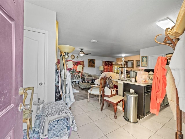 kitchen with light tile patterned floors, a textured ceiling, light countertops, and ceiling fan