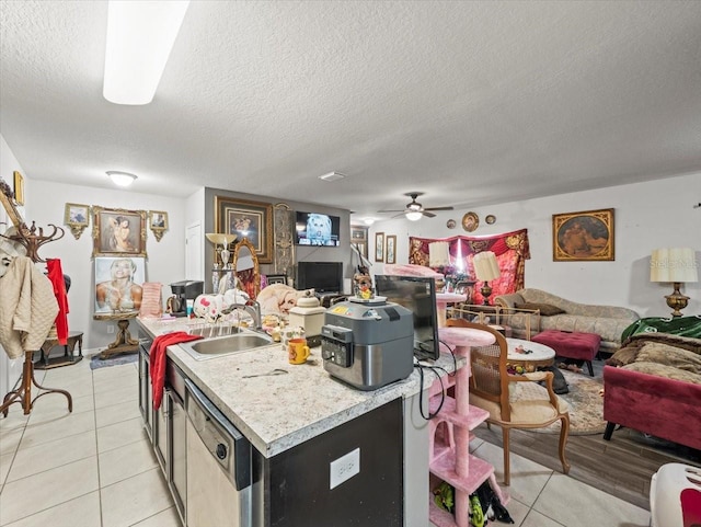 kitchen with dishwasher, light countertops, light tile patterned floors, and open floor plan