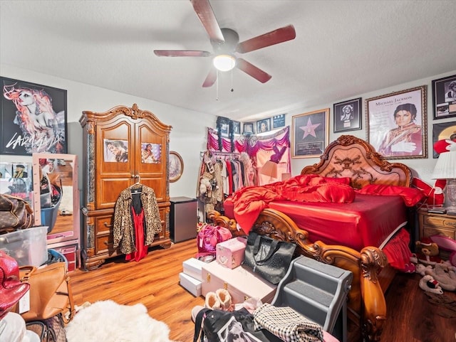 bedroom with ceiling fan, a textured ceiling, and wood finished floors