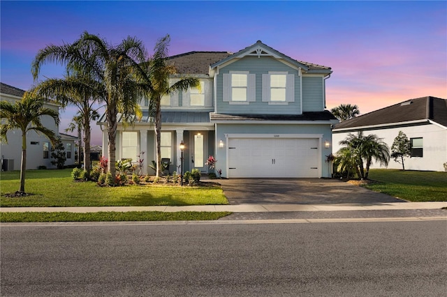 view of front of property featuring a tiled roof, driveway, an attached garage, and a front lawn