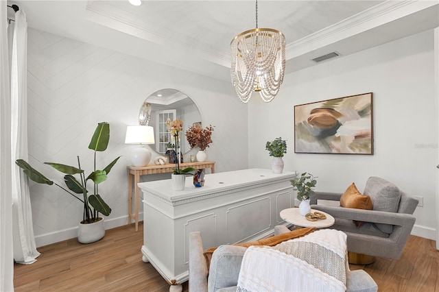 living area featuring visible vents, a tray ceiling, and ornamental molding