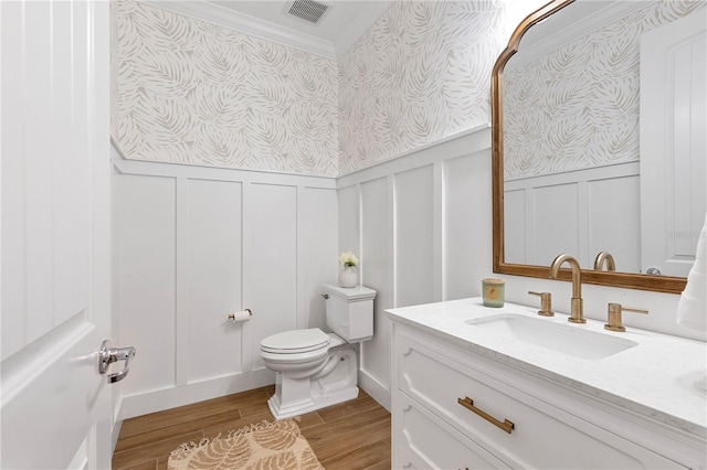 bathroom with wood finished floors, visible vents, wallpapered walls, wainscoting, and toilet