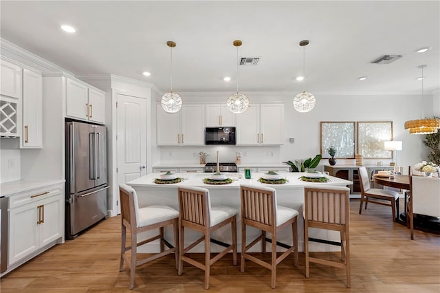 kitchen with light countertops, visible vents, high end fridge, and black microwave