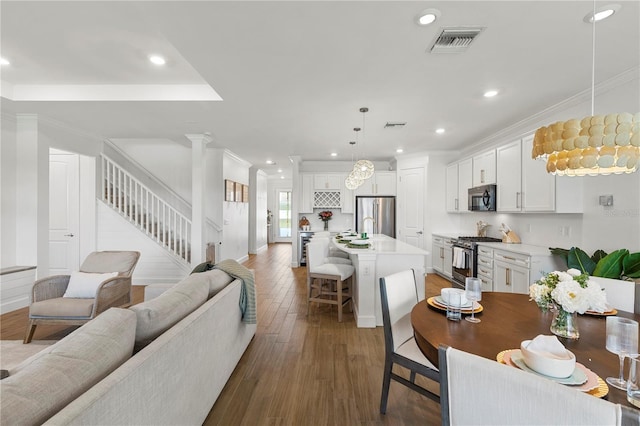 dining room featuring stairway, wood finished floors, visible vents, recessed lighting, and crown molding