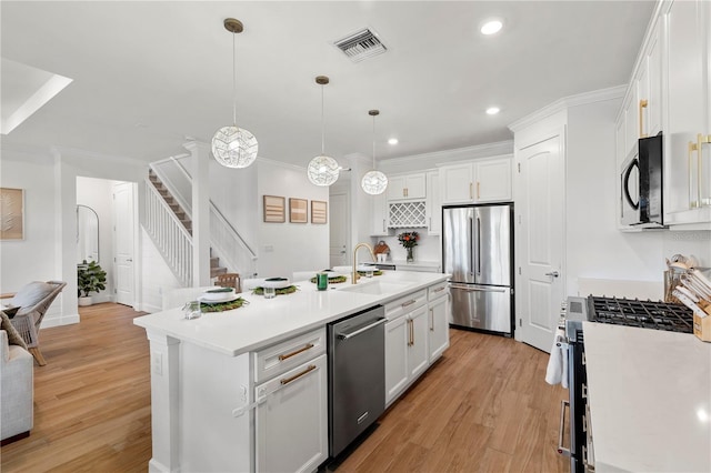 kitchen with visible vents, appliances with stainless steel finishes, white cabinetry, and light countertops