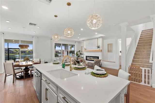 kitchen with light countertops, light wood-style floors, open floor plan, and a sink