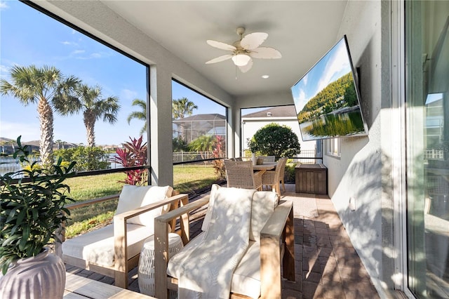 sunroom / solarium featuring a ceiling fan