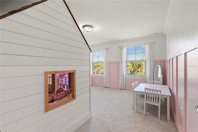 corridor with vaulted ceiling, crown molding, wood walls, and carpet floors