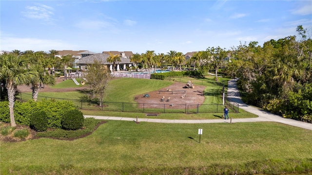 view of home's community featuring a lawn and fence