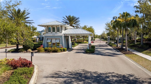 view of community with a carport, driveway, and a gate