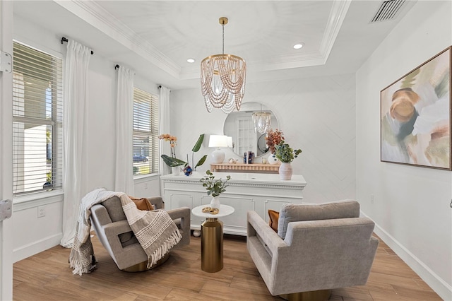 sitting room featuring visible vents, ornamental molding, wood finished floors, and a chandelier
