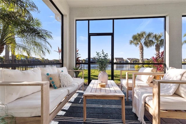 sunroom featuring a water view