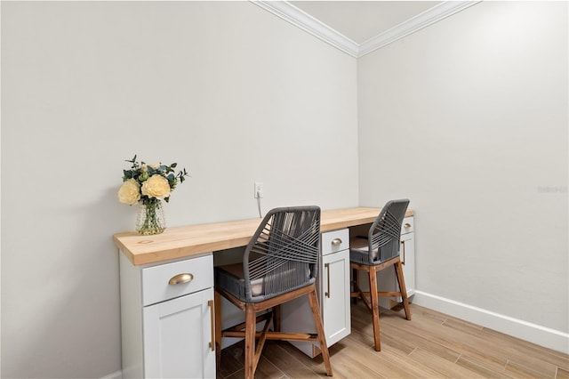 home office with crown molding, baseboards, and light wood finished floors