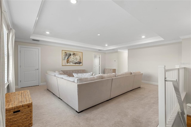 living area with a raised ceiling, ornamental molding, and light colored carpet