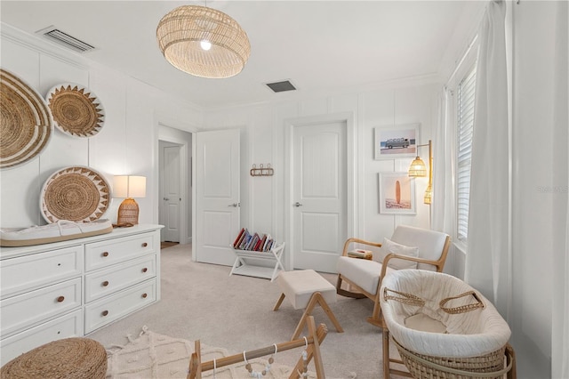 sitting room featuring visible vents, ornamental molding, and light colored carpet