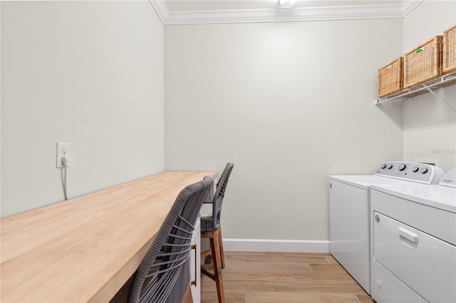 laundry room featuring laundry area, baseboards, light wood-style floors, ornamental molding, and washer and dryer