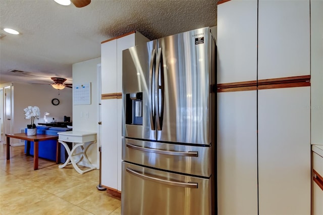 kitchen featuring a textured ceiling, ceiling fan, stainless steel refrigerator with ice dispenser, and white cabinets