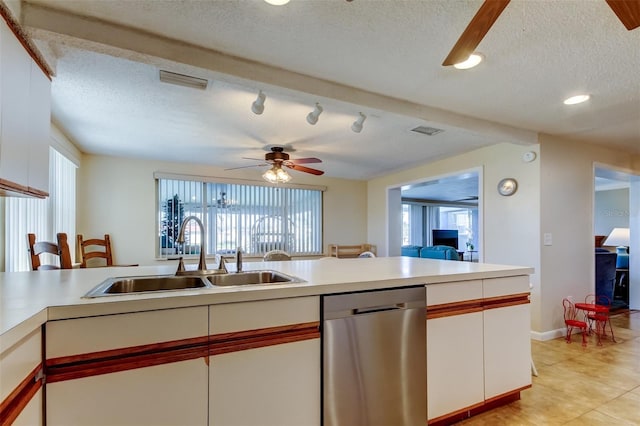 kitchen with visible vents, a sink, stainless steel dishwasher, a textured ceiling, and light countertops