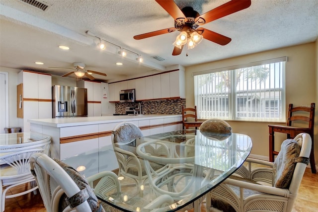 dining area featuring a ceiling fan, visible vents, and a textured ceiling