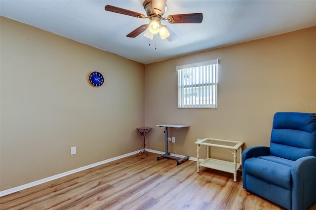 living area with ceiling fan, baseboards, and wood finished floors