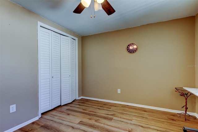 unfurnished bedroom with a closet, ceiling fan, baseboards, and wood finished floors