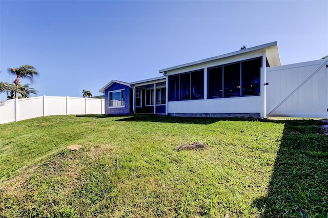 back of house with a sunroom, a lawn, and fence