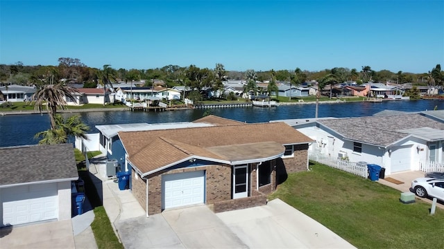 view of front of house featuring concrete driveway, brick siding, a residential view, and a water view