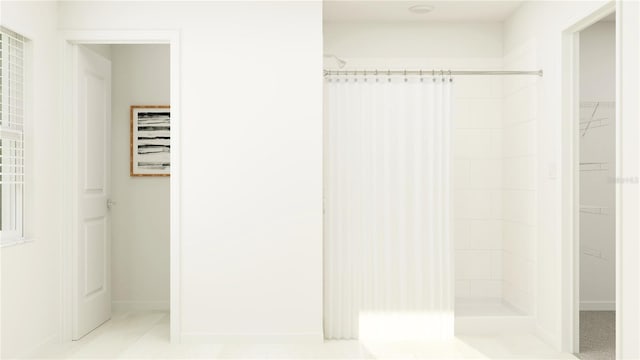 bathroom with a shower stall and a walk in closet