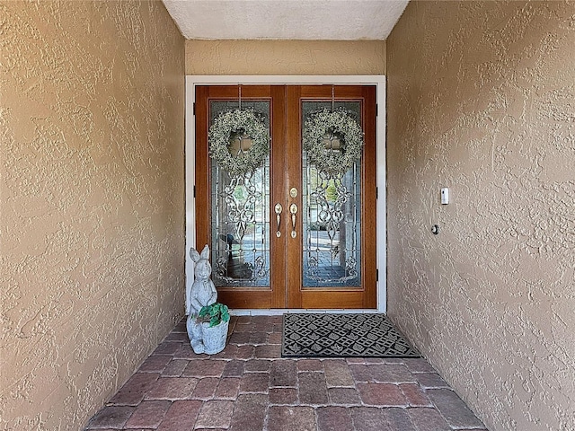 entrance to property featuring french doors and stucco siding