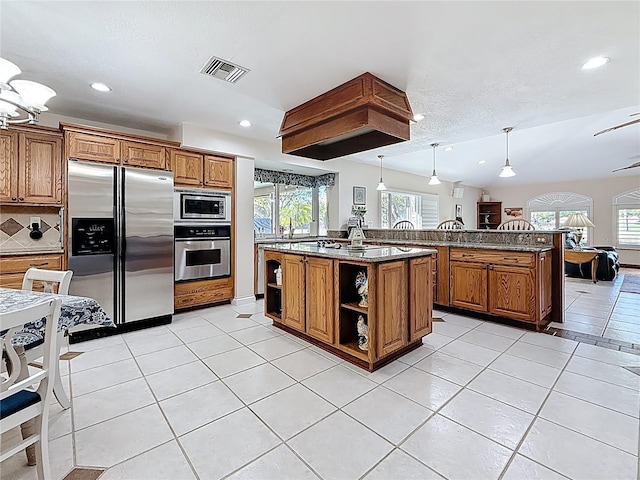 kitchen with stainless steel appliances, brown cabinets, and visible vents