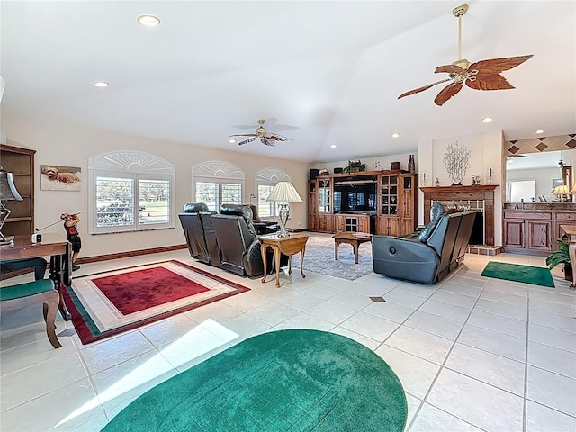 living room featuring light tile patterned flooring, a ceiling fan, recessed lighting, and a premium fireplace