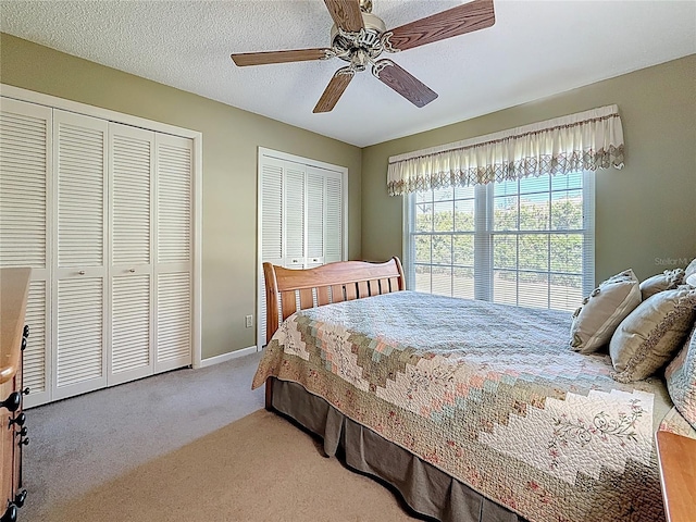 bedroom featuring baseboards, carpet floors, a textured ceiling, and a ceiling fan