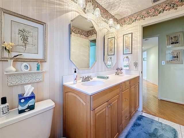 full bath featuring double vanity, tile patterned flooring, toilet, and a sink