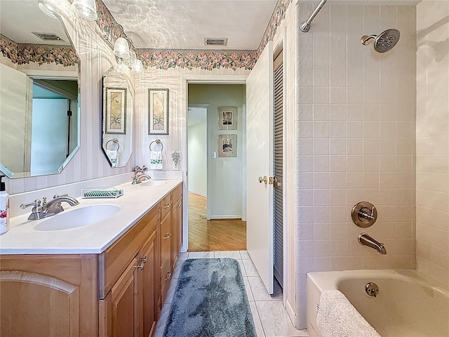 full bathroom with double vanity, visible vents, bathtub / shower combination, and a sink