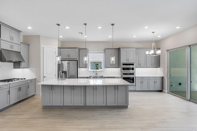 kitchen featuring a sink, gray cabinets, appliances with stainless steel finishes, light countertops, and under cabinet range hood