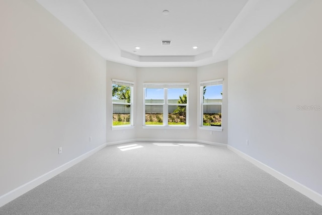 carpeted spare room with baseboards, a tray ceiling, visible vents, and recessed lighting