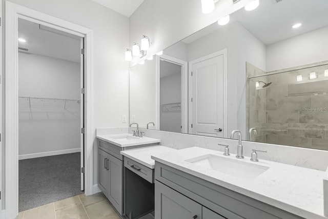 bathroom with a shower stall, a spacious closet, tile patterned floors, and vanity