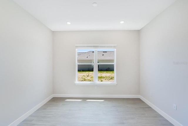 spare room with recessed lighting, light wood-type flooring, and baseboards