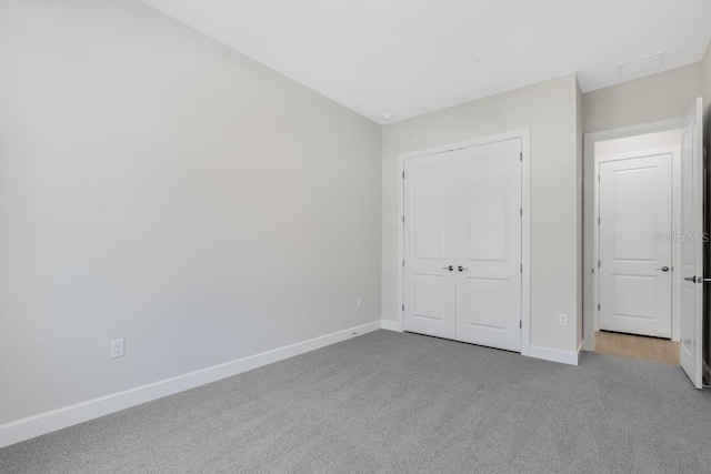 unfurnished bedroom featuring baseboards, carpet flooring, and a closet