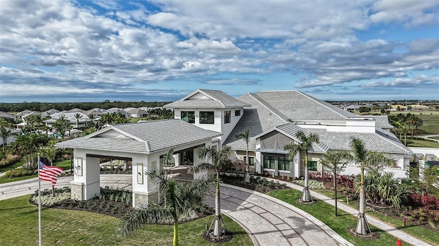 exterior space featuring a front lawn, stucco siding, a residential view, and a tile roof