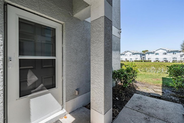 doorway to property featuring a residential view and stucco siding