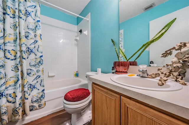 full bathroom featuring visible vents, toilet, shower / tub combo, a textured ceiling, and vanity