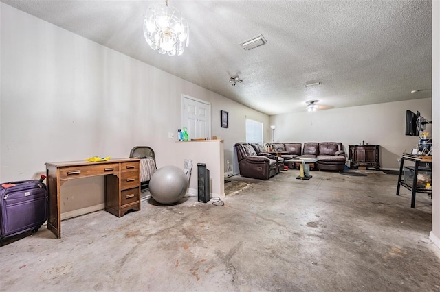 living area with visible vents, unfinished concrete flooring, a textured ceiling, and a chandelier