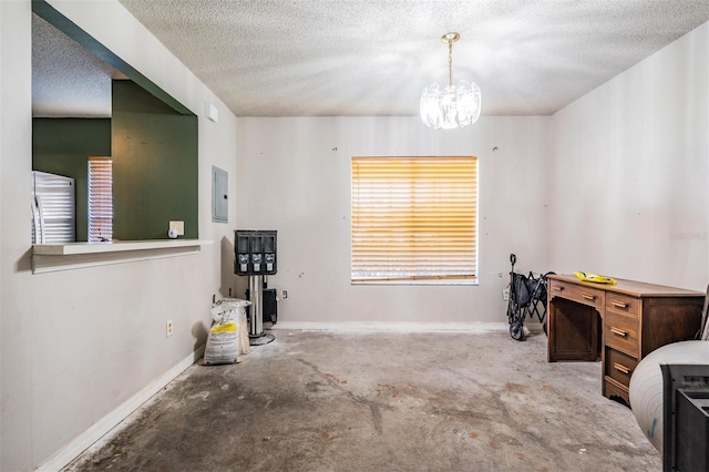 miscellaneous room featuring baseboards, an inviting chandelier, electric panel, a textured ceiling, and unfinished concrete flooring