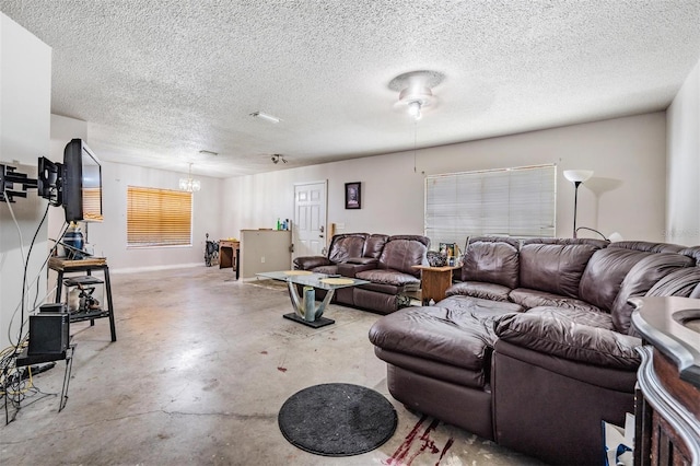 living area featuring a textured ceiling, concrete floors, and a chandelier