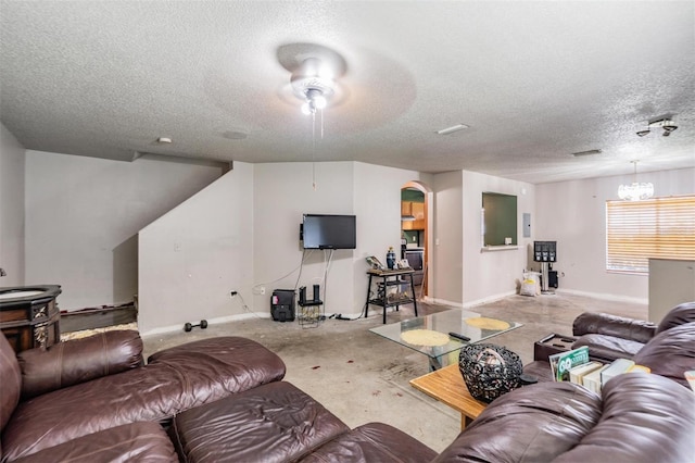 living area with a chandelier, baseboards, concrete floors, and a textured ceiling